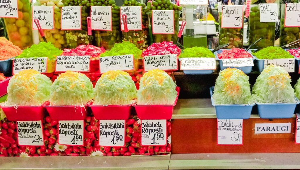 Red buckets filled with pickled cabbage on a table at Riga Central Market in Latvia