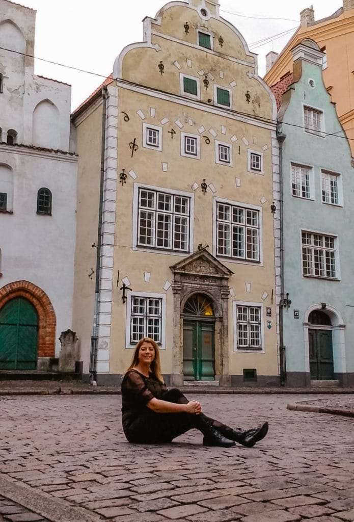 Eden Fite sitting in front of Three Brothers in Riga, Latvia