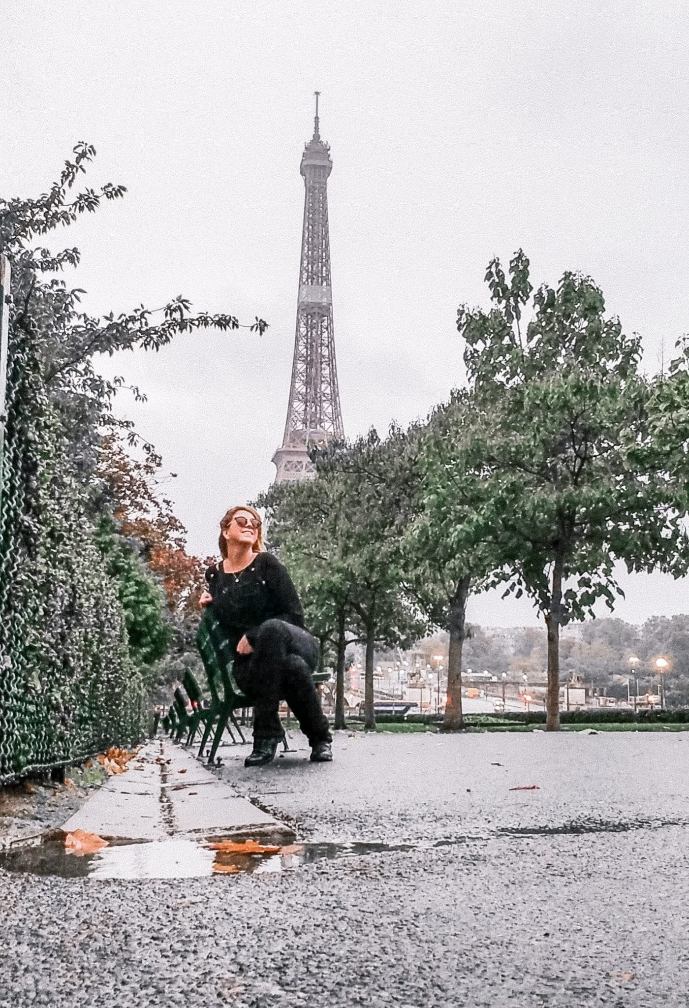 Eden Fite sitting on a bench with the Eiffel Tower in the background