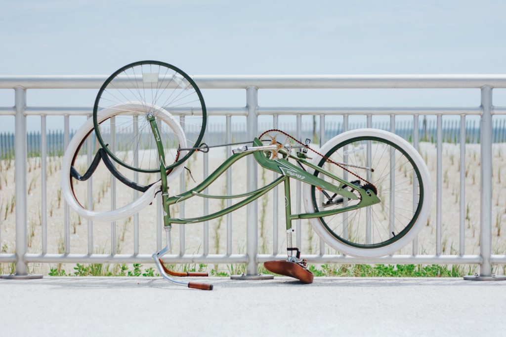 Green bicycle on a beach with flat tire