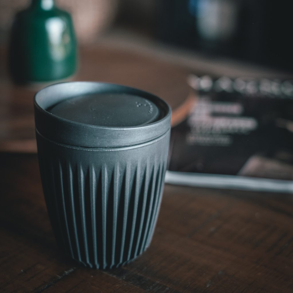 Reusable black coffee mug on a wooden table