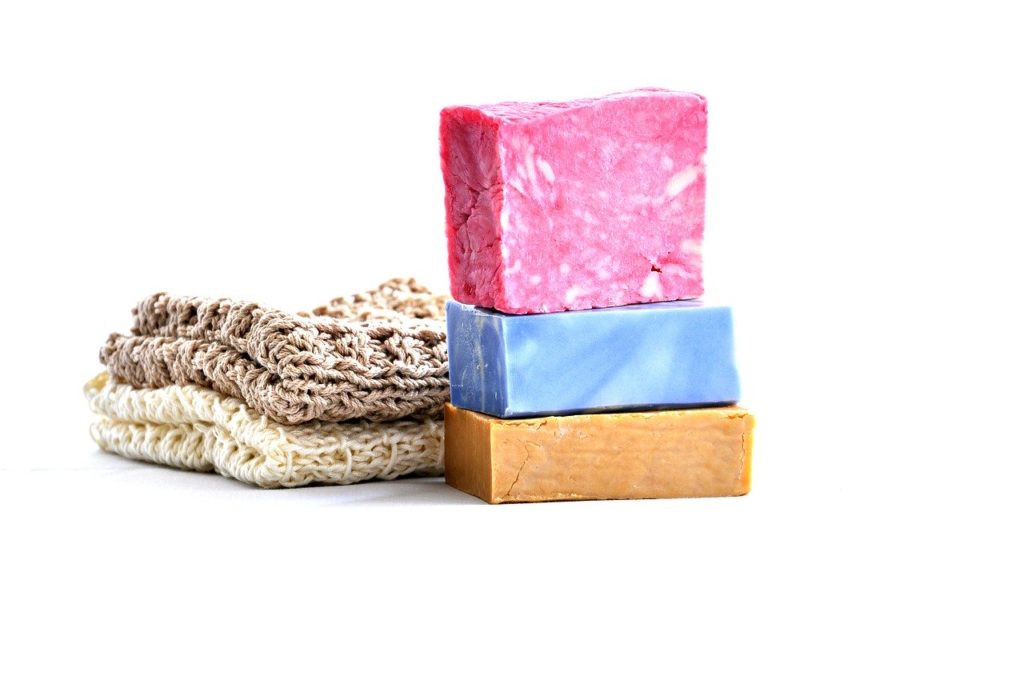 zero waste travel - colorful stack of soap bars on white table